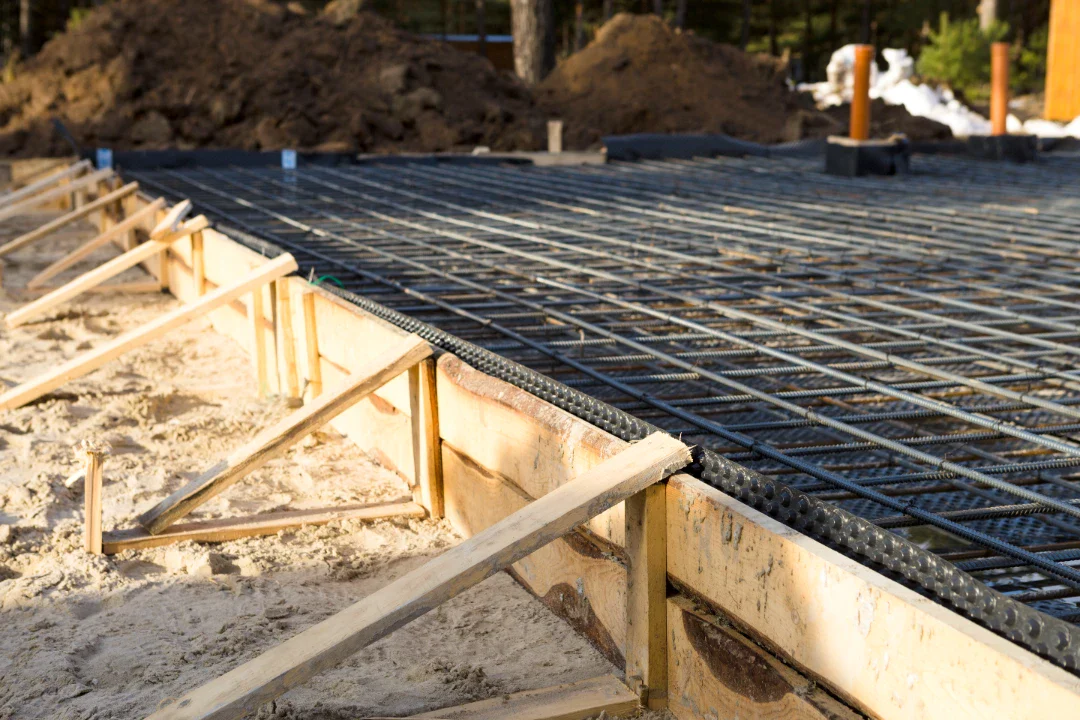 Betonfundament med armeringsjern og formbrædder til byggeri.